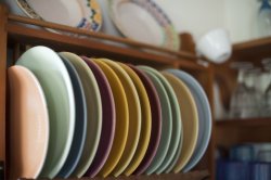 Assorted colorful plates in a wooden rack