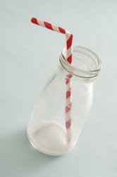 empty glass milk bottle with straw