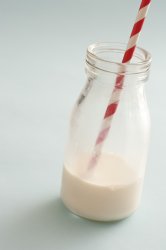 Small bottle half full with whole milk