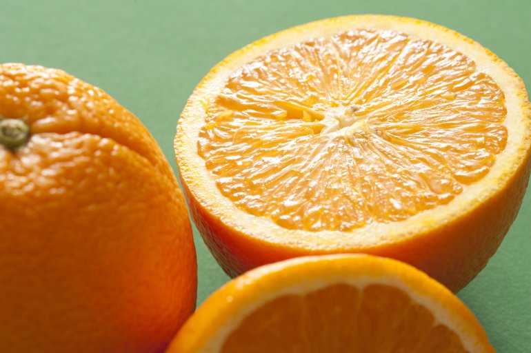 Close-up of half of orange on green background