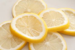 Heap of fresh lemon slices on white