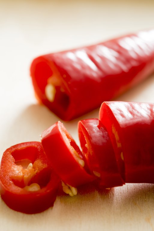 Close up on the sliced fresh pod of a red hot chill pepper to be used as a pungent flavouring in cooking
