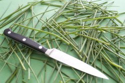 Kitchen knife with a scattering of fresh chives