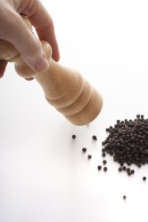 Milling black pepper with wooden mill