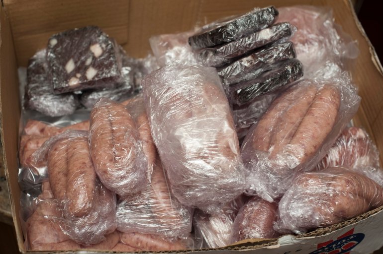 Assorted sausages and black pudding portioned and packed in plastic bags for freezing or storage