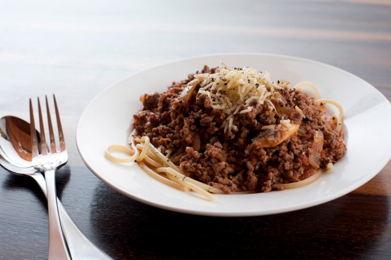 Spaghgetti Bolognese, or Bolognaise, topped with savoury spiced mince meat sprinkled with cheese for healthy Italian cuisine