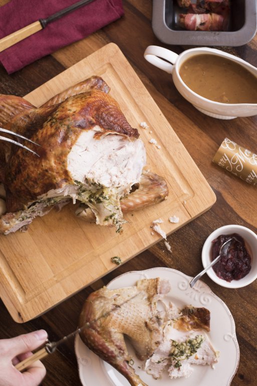High angle view of person cutting thanksgiving turkey on wooden board