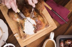 Man carving the breast of a Christmas turkey