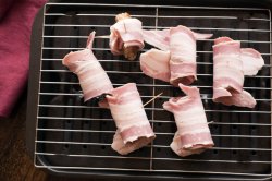 Making a batch of pigs in blankets or bacon rolls