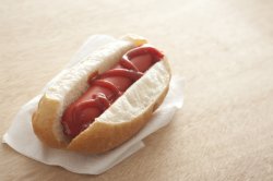 Hot dog and ketchup on a fresh roll
