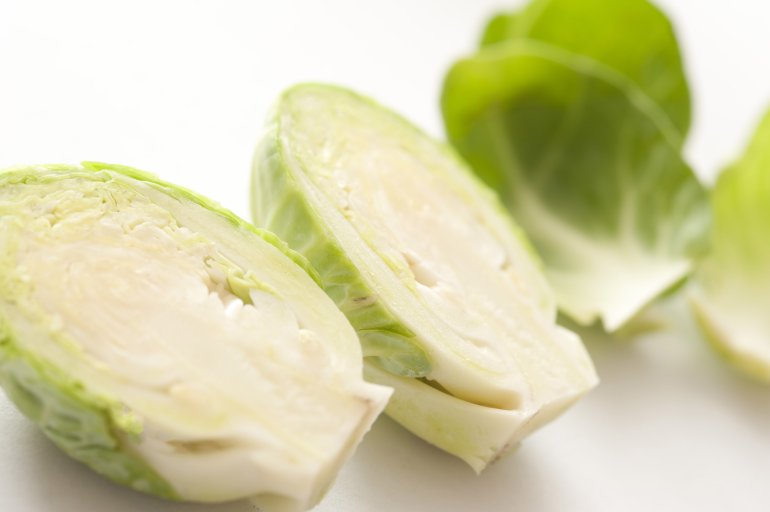 Raw Brussel sprouts head cut in half, viewed in macro close-up on white background