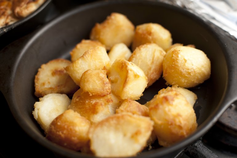 Close-up of delicious golden roast potatoes on in a skillet