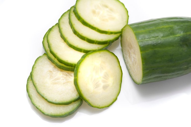 Freshly sliced cucumber for use as a salad ingredient in a health diet on a white background
